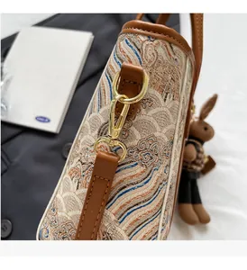 Detail of ukiyo-e wave pattern bag with leather trim and rabbit doll charm