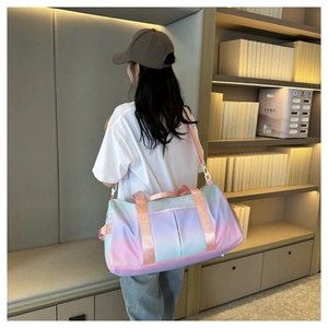 Detailed view of the gradient colored duffle bag featuring side pockets and pink handles