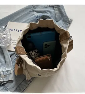 Vue de dessus de l'intérieur du sac seau en toile beige montrant un grand rangement
