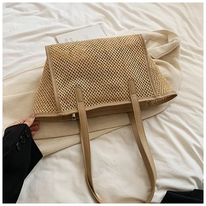 Détail macro du sac en paille montrant le tissage en maille et la bordure en cuir