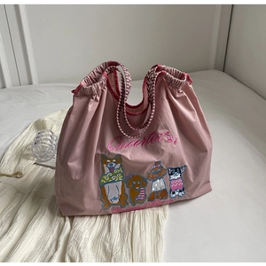 Detail der rosa Stofftasche mit niedlicher Hundestickerei und karierten Griffen