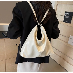 Detail of cream white faux leather backpack showing soft texture and geometric stitching