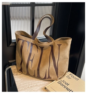 Gros plan du sac cabas camel vintage avec anses en cuir et typographie TELN imprimée