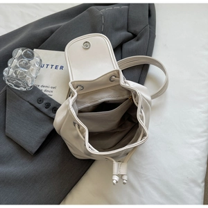 Detailed view of cream PU leather backpack with drawstring closure and fabric lining