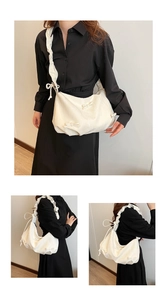 Detail of cream pleated shoulder bag featuring decorative bows and ruffled strap design