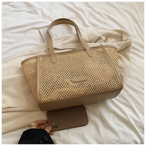 Vue détaillée du grand sac cabas en paille avec bordure en cuir comparé à un smartphone