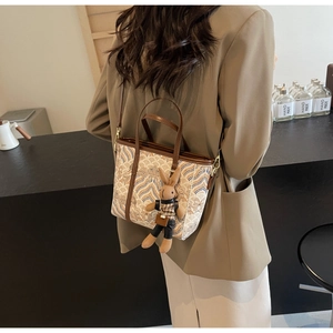 Detail of silk texture bucket bag with traditional pattern and cute bunny charm pendant