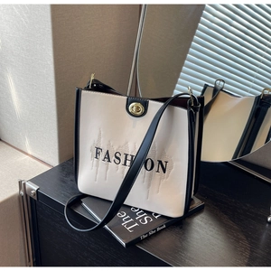 Detail of contrast bucket bag featuring embroidered logo and golden twist lock closure