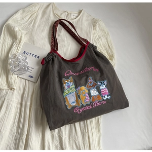 Detailansicht eines Nylon-Shoppers mit Hunde-Stickerei und rot gewebten Schultergurten