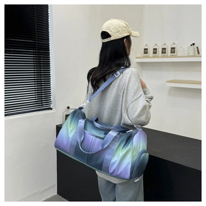Large gradient travel bag with shoulder strap shown carried by a model in a studio