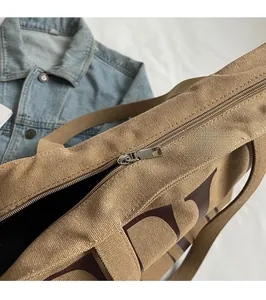 Détail de la fermeture éclair en métal lisse sur ce sac cabas en toile kaki
