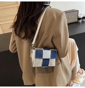 Detail showing woven silver leather and denim texture on the stylish crossbody bag