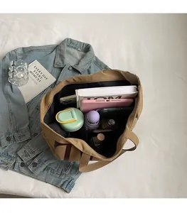 Intérieur spacieux du sac cabas en toile kaki montrant le rangement des objets quotidiens