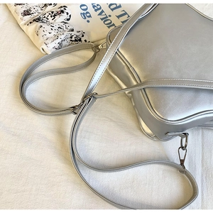 Détail du sac bandoulière argenté carré avec sangle réglable et accessoires métalliques