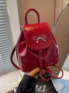 Glossy red mini backpack with silver bow buckle and drawstring straps for women