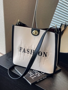 Minimalist black and white tote bag with FASHION embroidery and golden twist lock