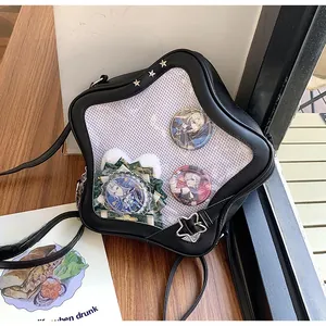 Détail du sac ita noir avec fenêtre transparente en étoile et badges de personnages