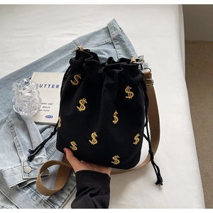 Sac seau en toile noire à la mode avec broderie signe dollar dorée et sangle tissée