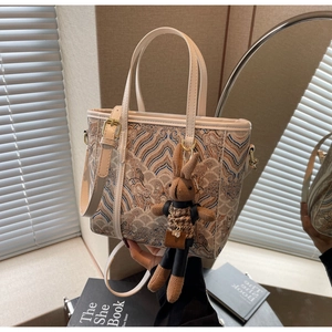 Detail of off-white tote bag with ethnic embroidery and cute brown bunny charm