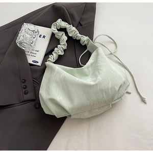 Macro view of mint green pleated hobo bag with unique marble texture and drawstring