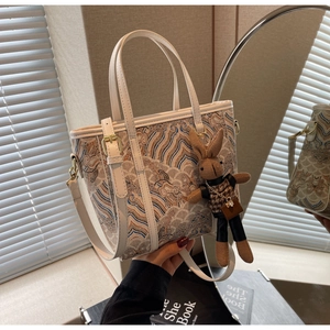 Detailed view of bucket bag with traditional cloud patterns and rabbit charm