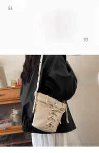 Detail der beigen Schnür-Beuteltasche mit Metallschnalle und matter Textur an der Schulter