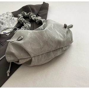 Detail of pleated shoulder strap and marble texture on minimalist faux leather bag