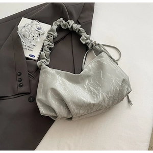 Detail of light gray pleated shoulder bag with glossy cracked texture and drawstring