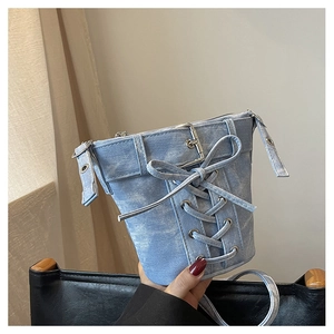 Detail der hellblauen Denim-Beuteltasche mit Kreuzschnürung und Metallschnalle