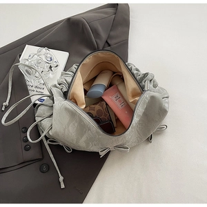 Interior view of pleated grey shoulder bag showing large capacity with personal items