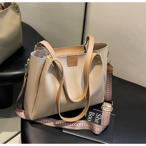 Dettaglio della borsa tote in pelle beige con rivetti dorati e tracolla a motivi geometrici