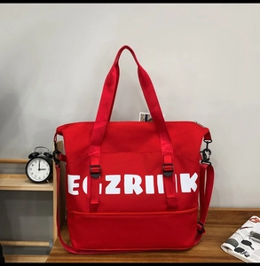 Detail of red large capacity Oxford cloth travel bag with buckles and white lettering print