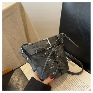 Detailansicht der dunkelgrauen Beuteltasche mit Schnürung und Metallösen auf einem Magazin