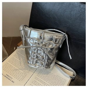 Detailaufnahme der silbernen Beuteltasche mit Metallic-Falten und dekorativer Schleife