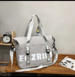 Detail view of large grey oxford fabric travel bag with EGZRIIK logo and adjustable strap