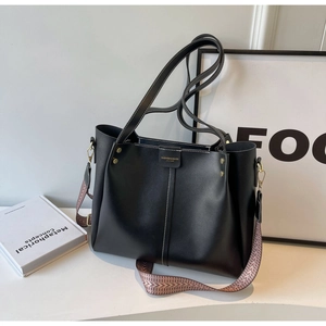 Dettaglio borsa tote nera con cuciture a contrasto e tracolla in tessuto vintage