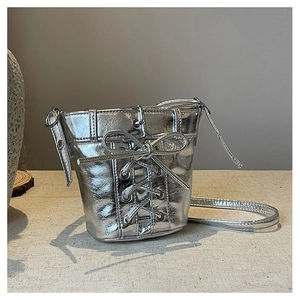 Detail der silbernen Spiegeleffekt-Beuteltasche mit Schnürung und Metallösen im Punk-Stil