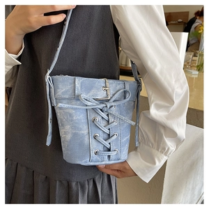 Nahaufnahme hellblaue Jeans-Beuteltasche mit Schnürung und schicken Metalldetails