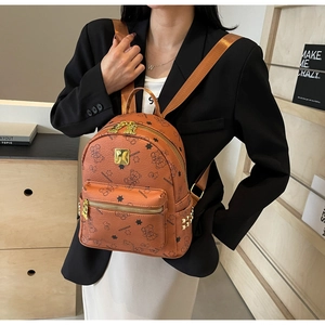 Details des braunen Kunstleder-Rucksacks mit Bärenprints und goldenen Metallnieten