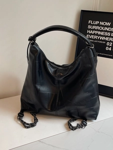 Vintage style black leather hobo bag with quilted texture and metal chain detail