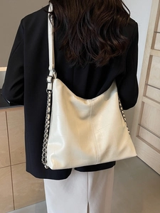 Cream-colored vintage hobo shoulder bag in pebbled leather shown on a model