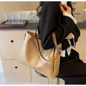 Dettaglio della capiente borsa tote beige e marrone con tracolla larga per pendolari