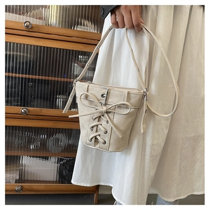 Detailansicht der beigen Canvas-Beuteltasche mit Schnürung im Korsett-Stil und Metallschnalle