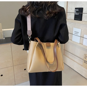 Dettaglio della borsa tote marrone chiaro con ampia tracolla a motivi geometrici intrecciati