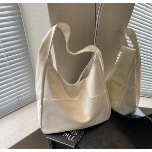 Close-up of the smooth cream tote bag showing glossy texture and Fashion label detail