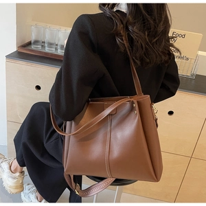 Dettaglio borsa tote grande in pelle marrone con tracolla larga in jacquard rimovibile