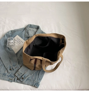 Détail de l'intérieur du sac cabas en toile marron avec poche zippée et doublure spacieuse