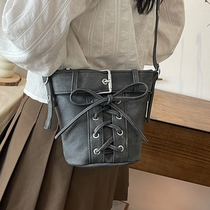 Dunkelgraue Denim-Beuteltasche mit Schnürschleife und Metallschnalle von Model getragen
