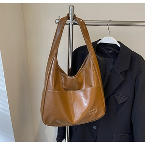 Detail view of brown tote bag with white contrast stitching and Fashion leather label