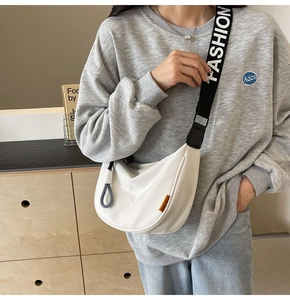 Weiße Nylon-Halbmondtasche mit breitem schwarzen Markengurt am Model gezeigt